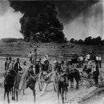 Shooting up an oil tank on fire to prevent explosion and wide spread fire. Oil men in big tank f.JPG