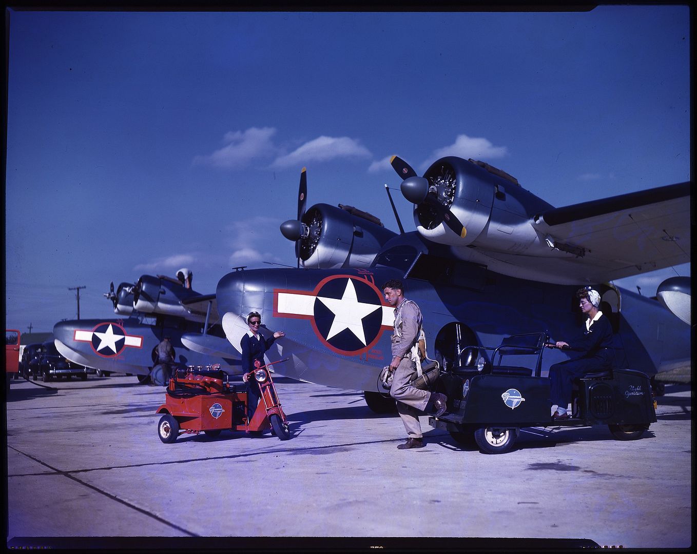 Grumman%20JRF%20Goose%20aircraft%20on%20the%20ground%20at%20the%20Grumman%20Aircraft%20facility%20on%20Long%20Island%20NY%20two%20women%20scooter%20drivers%20and%20a%20pilot%20are%20in%20the%20foreground%20circa%201943..jpg